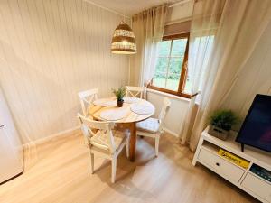 a dining room with a table and chairs and a television at Mäeotsa Country House in Laulasmaa