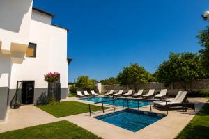 a swimming pool with lounge chairs next to a house at Side Mira Palace & Spa in Side +138 photos