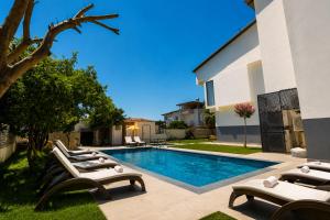 a swimming pool with lounge chairs next to a house at Side Mira Palace & Spa in Side