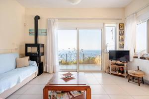 a living room with a couch and a large window at Michalis Holiday Home in Ravdhoúkha +52 photos