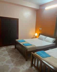 una habitación con dos camas con toallas azules encima en Silver Sands Malpe Beach Villa, en Udupi
