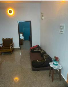 Una habitación con un sofá, una mesa y un espejo. en Silver Sands Malpe Beach Villa, en Udupi