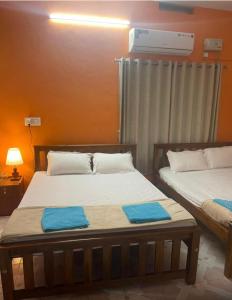 dos camas situadas una al lado de la otra en una habitación en Silver Sands Malpe Beach Villa, en Udupi 19 fotos más