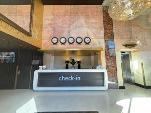 a check in sign in a building with clocks on the wall at ONOMO Hotel Waterfront in Cape Town