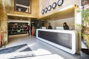 a large flat screen tv in a lobby with people at ONOMO Hotel Waterfront in Cape Town