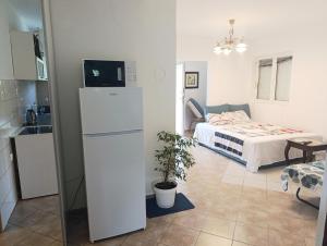 a small room with a bed and a white refrigerator at Green Valley GV in Kotor
