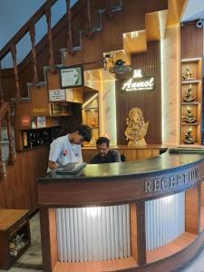 two men standing at a bar in a restaurant at Hotel Anmol in Dehradun
