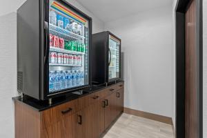 a room with a refrigerator with drinks in it at HomeTowne Studios by Red Roof Bradenton in Bradenton