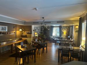 a restaurant with tables and chairs in a room at Lokatten Wärdshus in Los