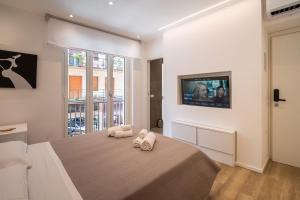 a bedroom with a bed and a tv on a wall at ABBA ROOMS in Cagliari