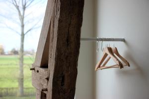 a wooden birdhouse hanging on the side of a window at Het Plategoed in Oosthoek