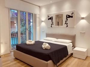 a bedroom with a bed with two towels on it at ABBA ROOMS in Cagliari