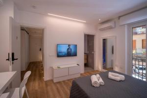 a room with a bed and a tv on a wall at ABBA ROOMS in Cagliari