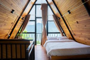 a bed in a room with a large window at The Edge Villa & Retreat in Pokhara
