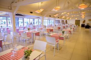 a dining room with tables and white chairs at Oasis Belorizonte in Santa Maria