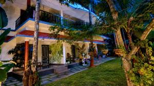a house with palm trees in front of it at Aryavilla Heritage in Varkala
