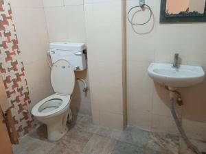 a bathroom with a toilet and a sink at Hotel Maa Arya in Lucknow