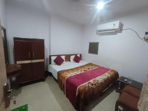 a bedroom with a bed and a dresser in it at Hotel Maa Arya in Lucknow