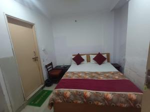a small bedroom with a bed and a door at Hotel Maa Arya in Lucknow