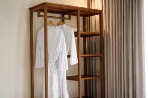 a wooden shelf with white clothes on it next to a curtain at SARALA sidemen guest house in Sidemen
