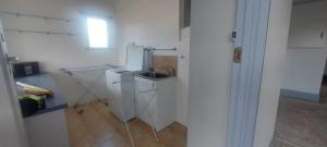 a white kitchen with a sink and a refrigerator at Mary's Place in Devonport