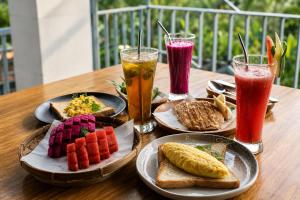a wooden table with plates of food and drinks at SARALA sidemen guest house in Sidemen +9 photos