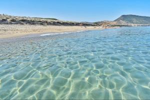 a beach with clear water and a sandy beach at Valledoria Central Modern Studio in Valledoria
