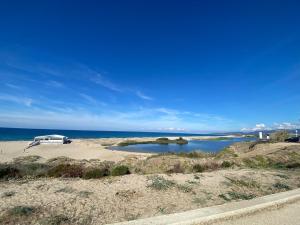 a camper van parked on the beach near the water at Valledoria Central Modern Studio in Valledoria