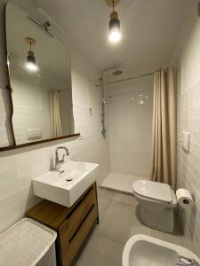 a bathroom with a sink and a toilet and a mirror at Valledoria Central Modern Studio in Valledoria