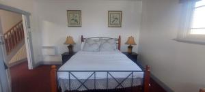 a bedroom with a bed with two lamps and a staircase at Mary's Place in Devonport