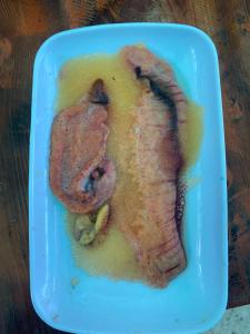 a piece of meat in a blue dish on a table at La Bahia de Makale in Pisco