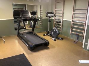 a gym with a treadmill and two exercise bikes at Lokatten Wärdshus in Los