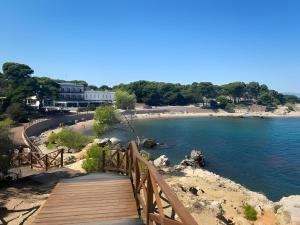 a wooden bridge over a beach next to the water at Cal Piano in Palol de Rebardit