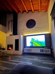a living room with a large television and a fireplace at Cal Piano in Palol de Rebardit