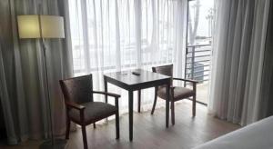 a dining room table and chairs in a room with a window at Huntington Beach Inn in Huntington Beach