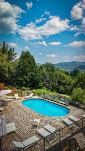 a swimming pool with lounge chairs on a patio at Moon Village Comarnic in Sinaia