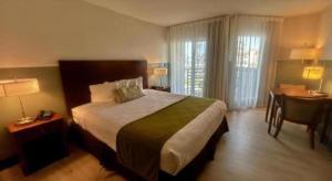 a hotel room with a large bed and a desk at Huntington Beach Inn in Huntington Beach