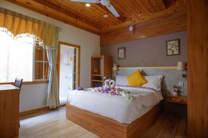 a bedroom with a large bed with flowers on it at The Blue Cave Maldives in Kendhoo