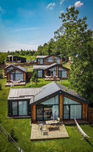 a large house with a wooden deck in the grass at Moon Village Comarnic in Sinaia