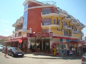 a building on a street with cars parked in front of it at Hotel Bellisimo in Lozenets