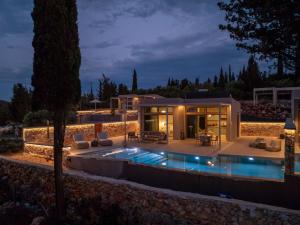 a house with a swimming pool at night at Veragi Boutique Villas in Lefkada