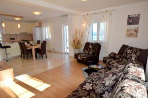 a living room with a couch and a dining room at Apartments Celebrini in Malinska