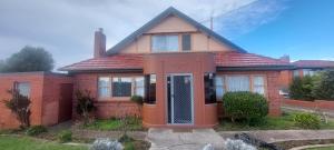 a red brick house with a door in front of it at Mary's Place in Devonport