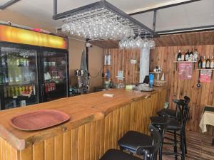 a bar with chairs and a counter with wine bottles at Kalinka pansiyon in Cıralı