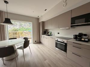 a kitchen with a table and a table and chairs at Geirangerbooking in Geiranger