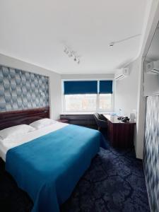 a bedroom with a large blue bed and a desk at Tourist Hotel Complex in Kyiv