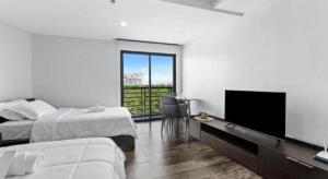 a bedroom with two beds and a flat screen tv at Espacio Hotel in Manila +55 photos