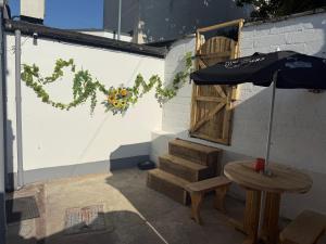 a patio with a table and an umbrella and stairs at Grande Italia Rooms Comfort Italian Hospitality 4 in Ebley