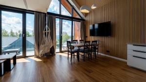 a dining room with a table and chairs and windows at Wisła View, Sun&Snow in Wisła