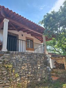 a house with a stone wall and a fence at Casa do Trola - Ferreira do Zêzere in Águas Belas
